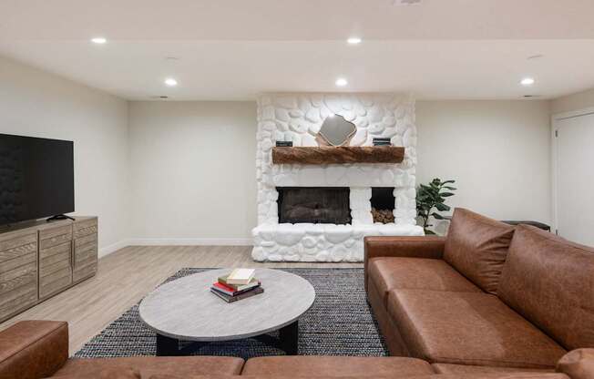 a living room with a couch and a coffee table and a fireplace