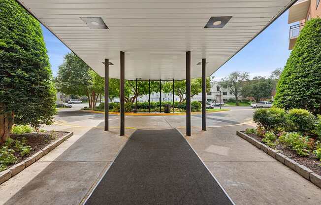 A covered walkway with a black pathway and a white ceiling.