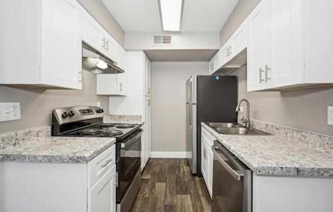 A kitchen with white cabinets and a granite countertop.