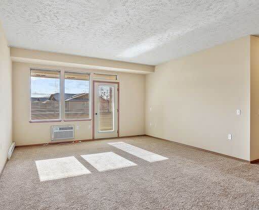 an empty living room with a door and a window