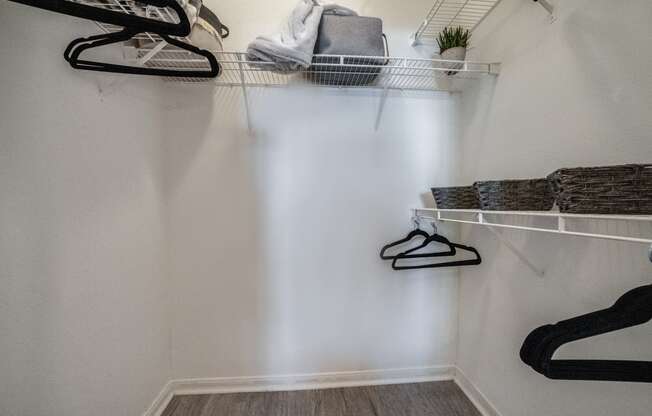 a walk in closet with shelves and shoes on the wall