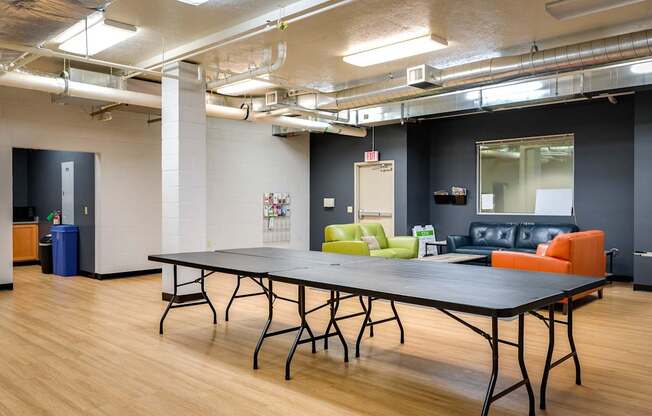 a room with a ping pong table and couches