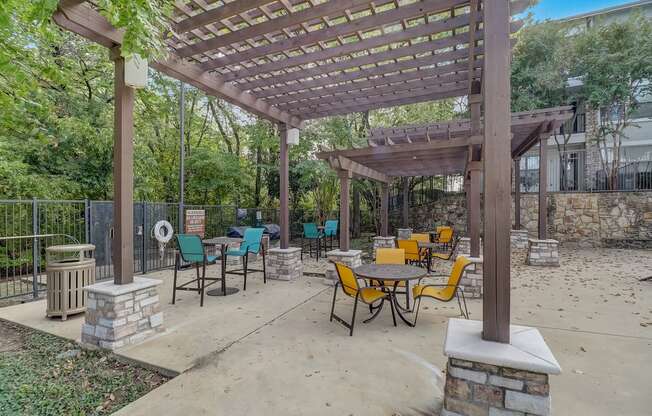 a patio with tables and chairs and a pergola