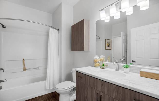 A white bathroom with a toilet, sink, and shower.