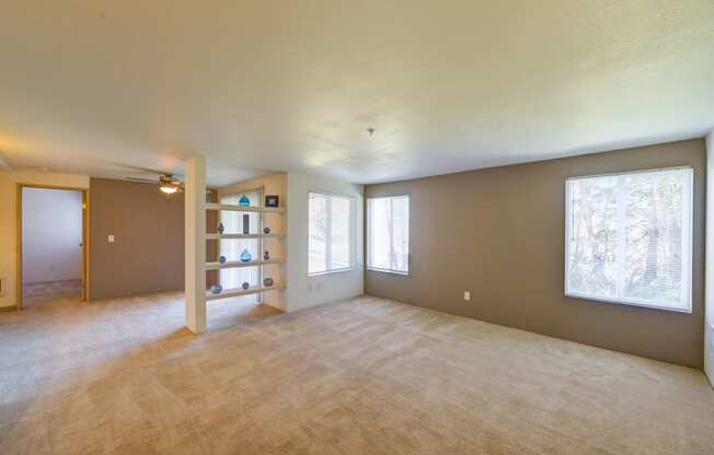 the living room and dining room of an empty house with a large window