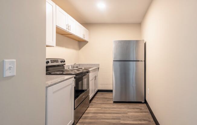 a kitchen with white cabinets and a stainless steel refrigerator