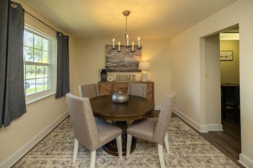 A dining room with a wooden table and chairs.