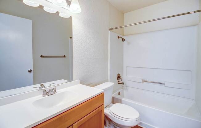 A white bathroom with a toilet, sink, and bathtub.