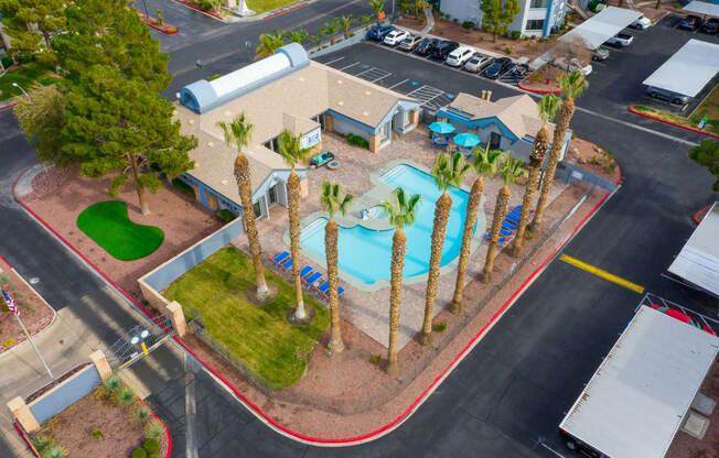 an aerial view of a pool and palm trees in a parking lot