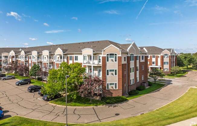 A large apartment complex with a parking lot in front.