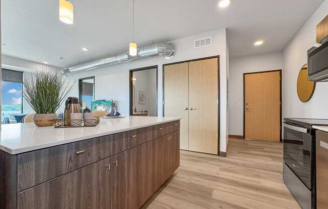 a kitchen with an island and a door to a living room