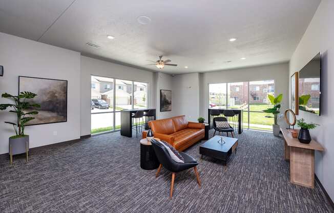A spacious living room with grey carpeting and furniture.