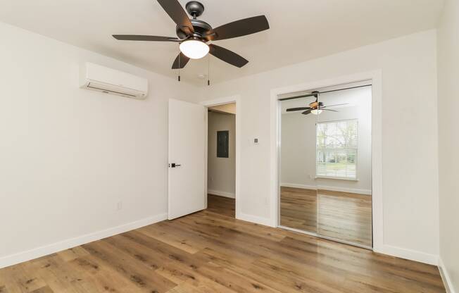 a bedroom with hardwood floors and a ceiling fan