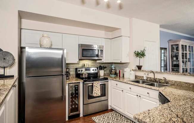 Apartment kitchen with stainless appliances and granite counters at Magnolia Carillon