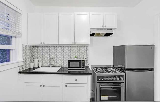 A kitchen with white cabinets and a black stove top.