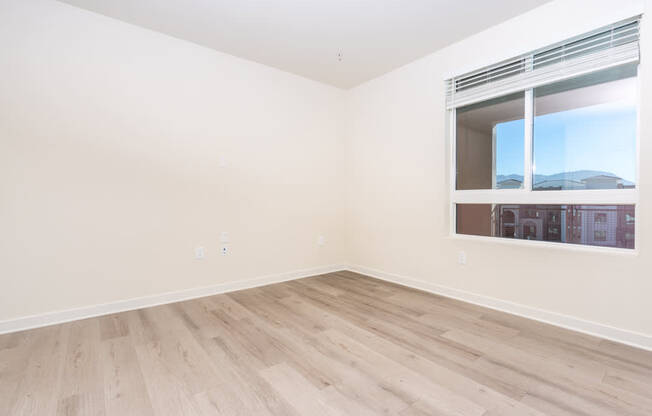 A room with a window and wooden flooring.