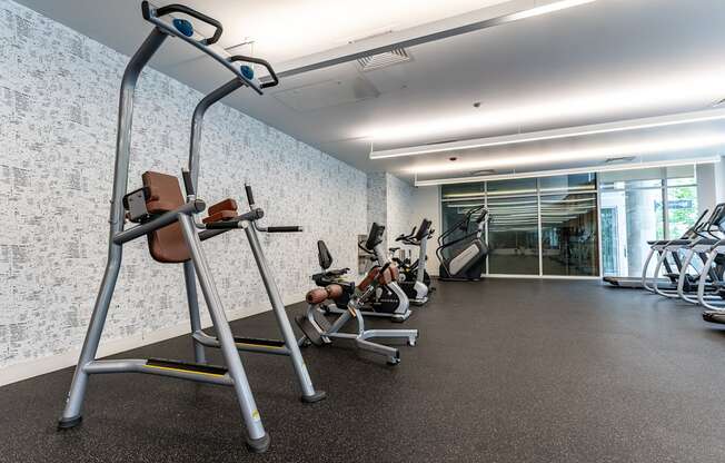 a gym with various exercise equipment in a building with a glass door