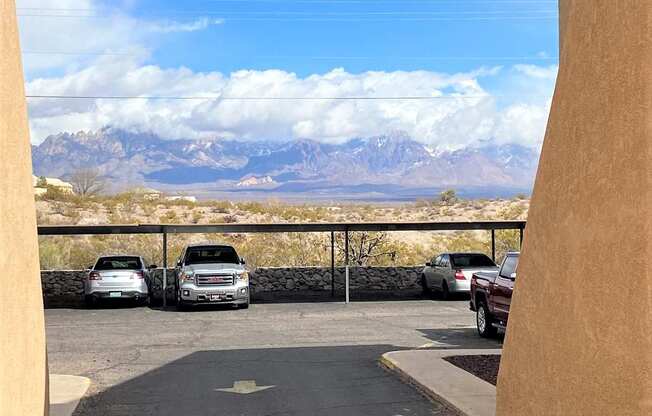 A parking lot with cars and a mountain range in the background.