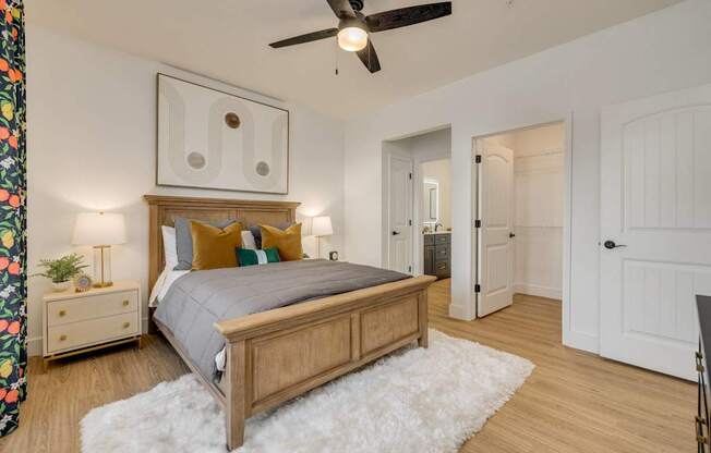 A bedroom with a bed, nightstand, and a ceiling fan.