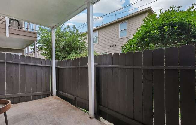 A patio with a black fence and a white awning.