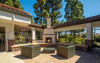 A patio with a fireplace and seating area.