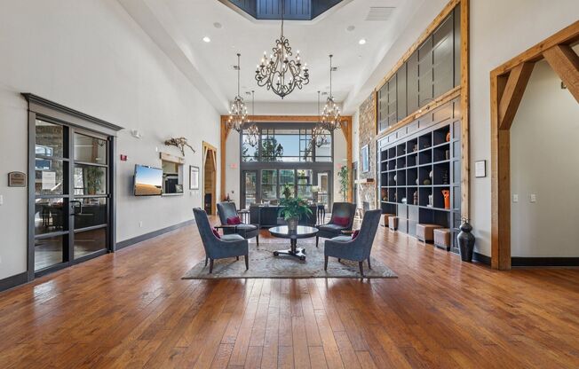 A large room with a wooden floor and a chandelier hanging from the ceiling.