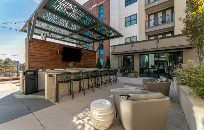A patio with a bar and seating area.