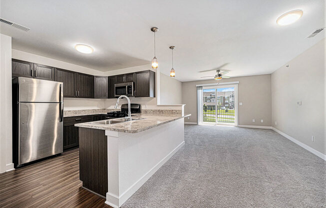 an open kitchen and living room with a stainless steel appliances at Trade Winds Apartment Homes, Elkhorn, Nebraska