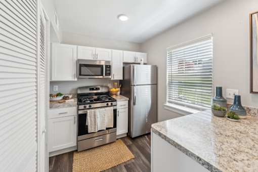 A kitchen with a refrigerator, stove, and microwave at Staples Mill Townhomes Apartments, Richmond, VA