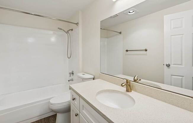 A white bathroom with a toilet, sink, and bathtub.