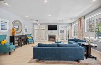 a living room with blue couches and chairs and a fireplace