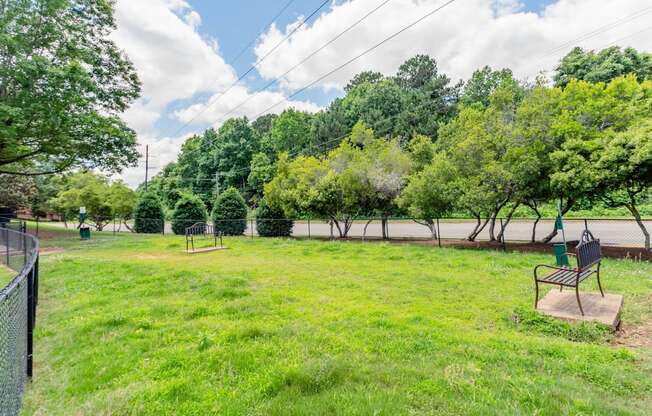 a park with a bench in the grass and trees