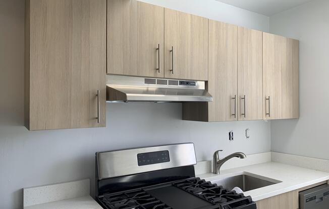 A modern kitchen with a stove top oven and a microwave above it.