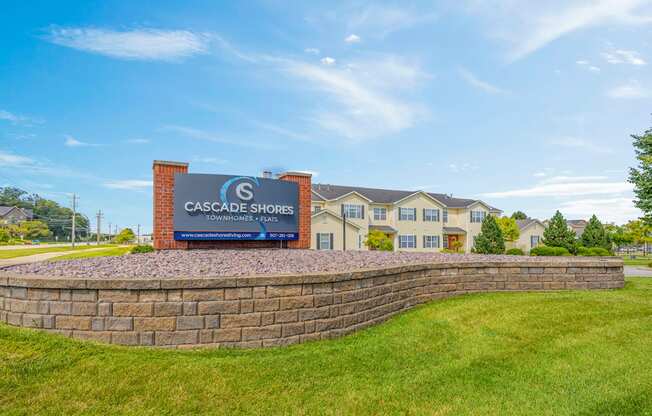 A sign for Cascade Shores Apartments is in front of a building.