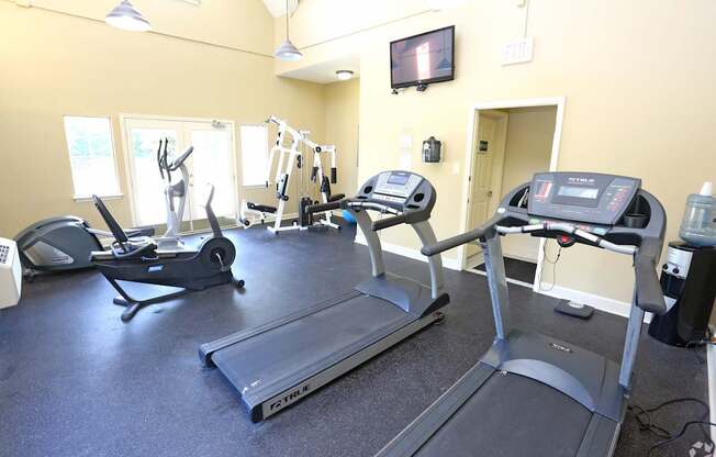 A gym with treadmills, elliptical machines, and other exercise equipment.