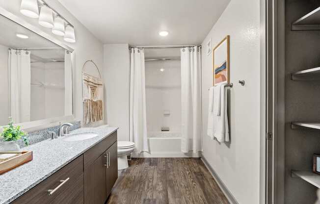 A bathroom with a white toilet, a white tub, and a white sink.