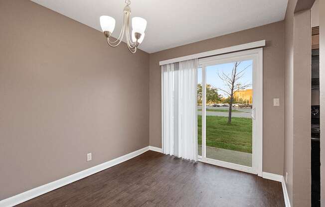 an empty living room with a sliding glass door to a yard