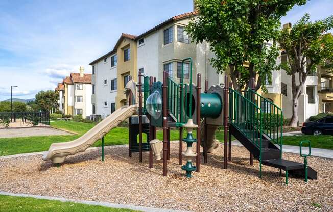 A playground with a green slide and a brown slide.