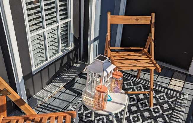 a small porch with two chairs and a table and a door