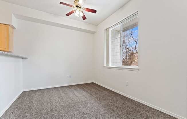 A room with a ceiling fan and a window.