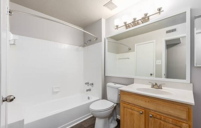 A white bathroom with a toilet, sink, and bathtub.