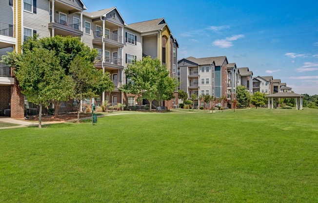 an apartment complex with a large green lawn