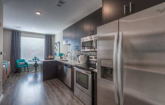 a kitchen with stainless steel appliances and a wooden floor