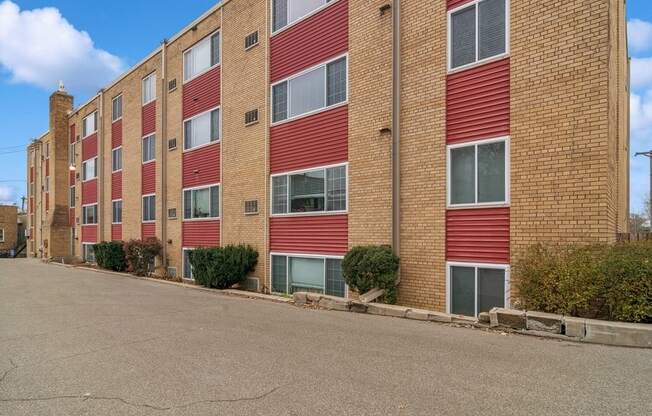 A red brick building with a parking lot in front.