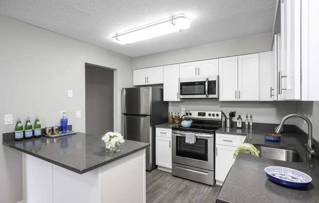 a kitchen with white cabinets and stainless steel appliances