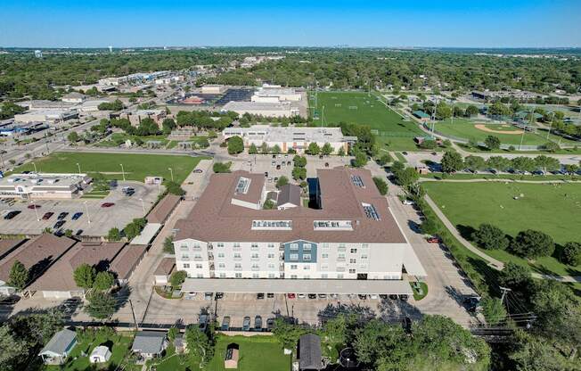 an aerial view of a campus with a field and buildings