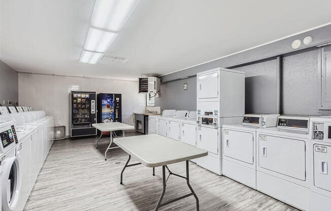 a laundry room with white appliances and a table