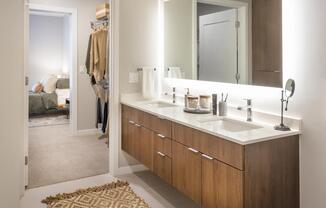 Ultra modern bathroom with floating vanities and pass-through closet.