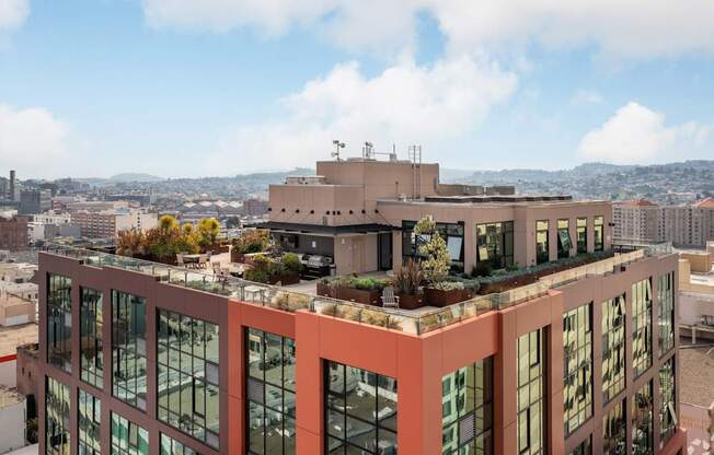 A modern building with a lot of windows and plants on the roof.
