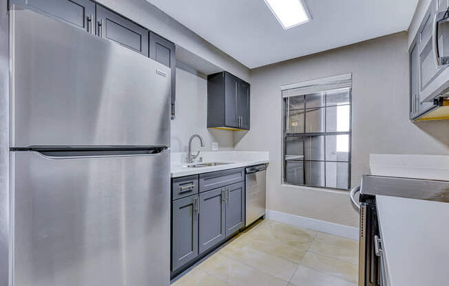 a renovated kitchen with stainless steel appliances and a window